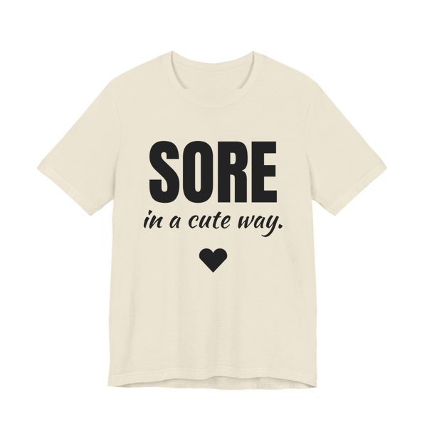 Natural t-shirt printed in dark ink with a heart and the words "Sore in a Cute Way."