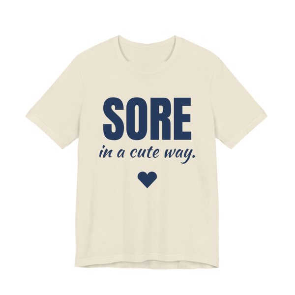 Natural t-shirt printed in navy blue ink with a heart and the words "Sore in a Cute Way."