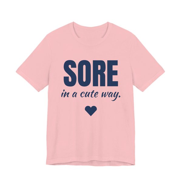 Pink t-shirt printed in navy blue ink with a heart and the words "Sore in a Cute Way."
