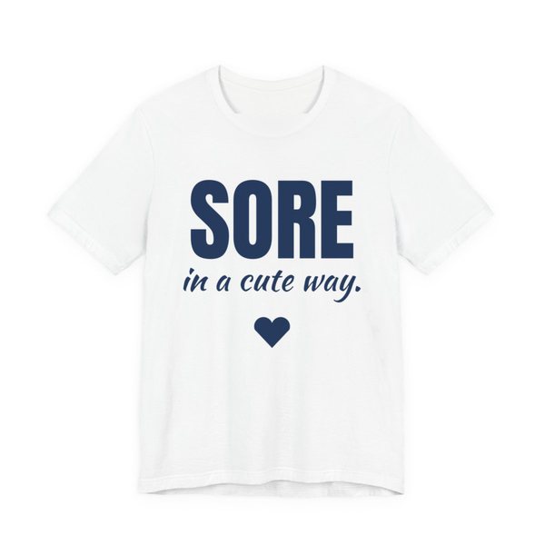 White t-shirt printed in navy blue ink with a heart and the words "Sore in a Cute Way."