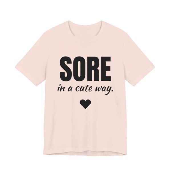 Soft Pink t-shirt printed in dark ink with a heart and the words "Sore in a Cute Way."