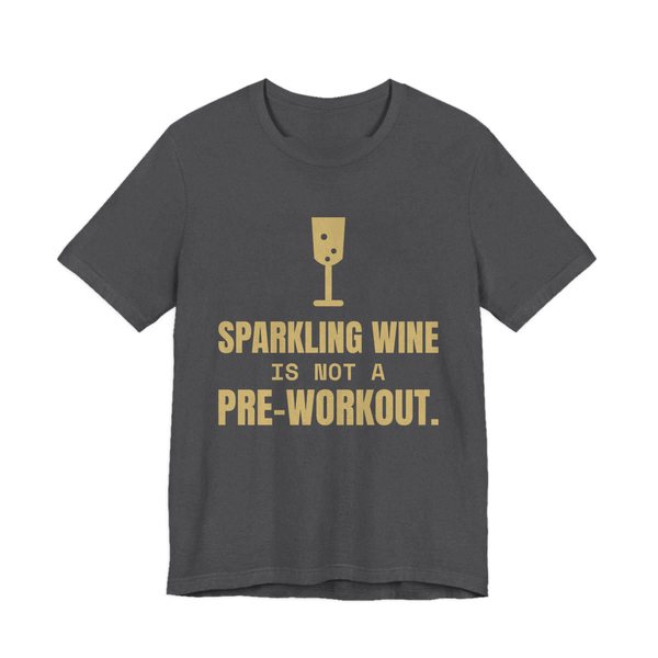 Dark Grey Heather t-shirt printed in champagne gold ink with a glass of sparkling wine and the words “Sparkling Wine Is Not a Pre-Workout.”