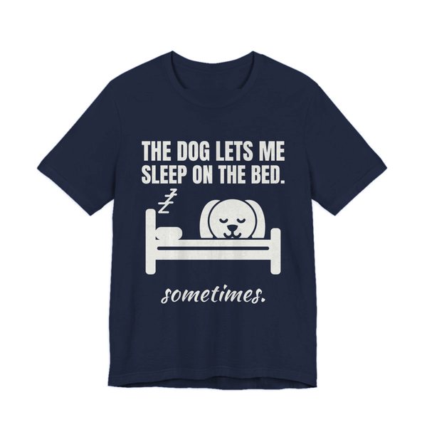 Navy t-shirt printed in off-white ink with a dog asleep in a bed and the words “The Dog Lets Me Sleep on the Bed. Sometimes.”