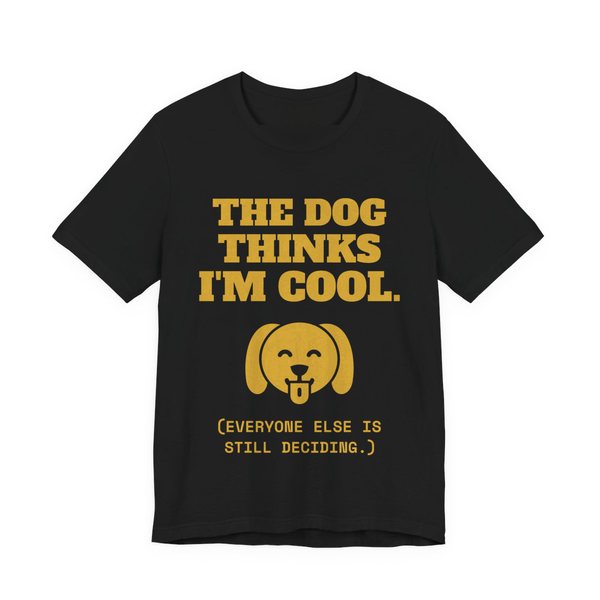 Black t-shirt printed in gold ink with a happy dog face and the words “The Dog Thinks I'm Cool. (Everyone else is still deciding.)”