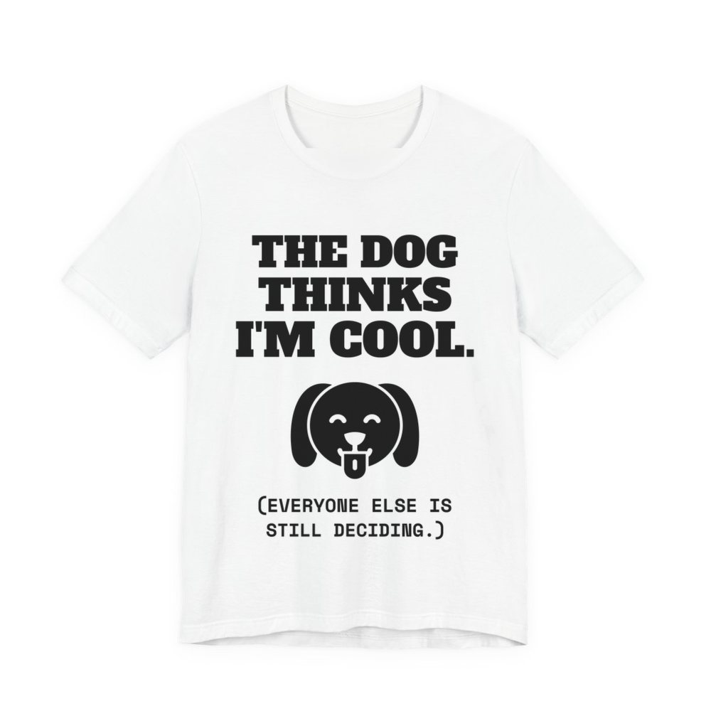 White t-shirt printed in dark ink with a happy dog face and the words “The Dog Thinks I'm Cool. (Everyone else is still deciding.)”