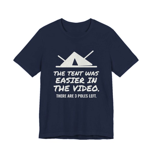 Navy t-shirt printed in off-white ink with a pitched tent with spare poles and the words “The Tent Was Easier in the Video. There are 3 poles left.”