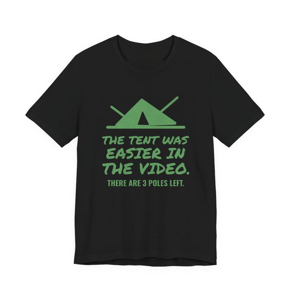 Black t-shirt printed in pine green ink with a pitched tent with spare poles and the words “The Tent Was Easier in the Video. There are 3 poles left.”