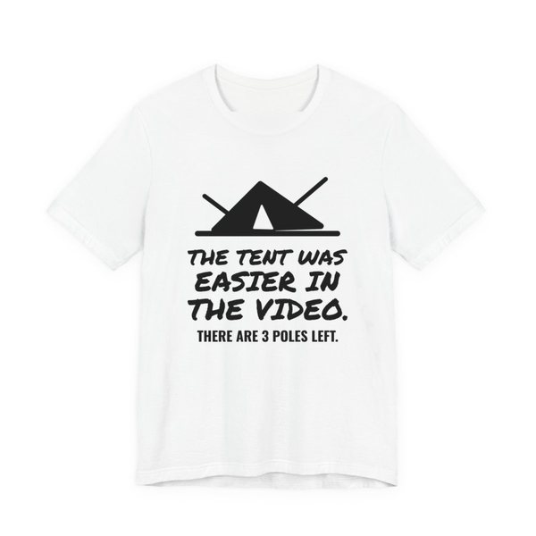 White t-shirt printed in dark ink with a pitched tent with spare poles and the words “The Tent Was Easier in the Video. There are 3 poles left.”