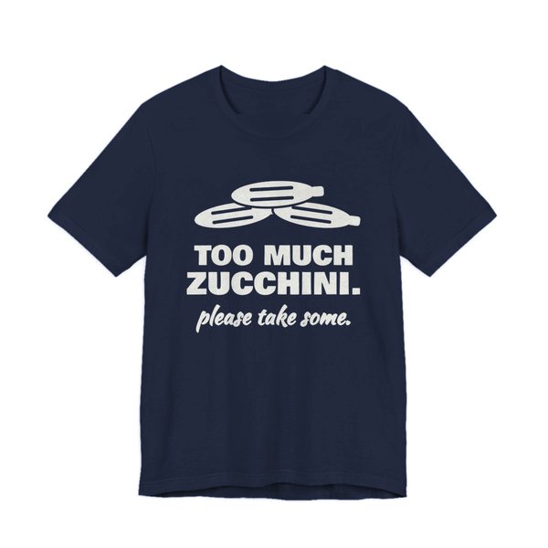 Navy t-shirt printed in off-white ink with a pile of zucchini and the words “Too Much Zucchini. Please Take Some.”