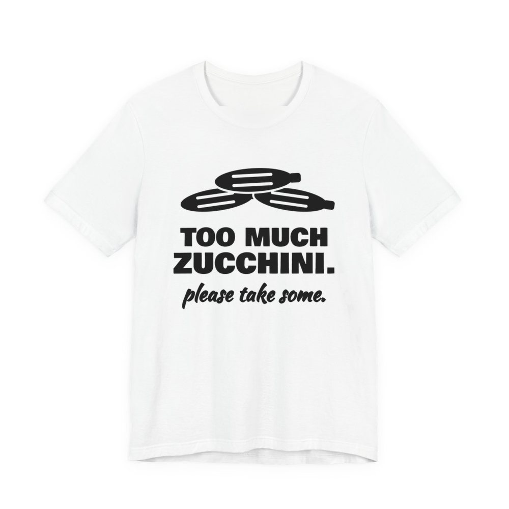 White t-shirt printed in dark ink with a pile of zucchini and the words “Too Much Zucchini. Please Take Some.”