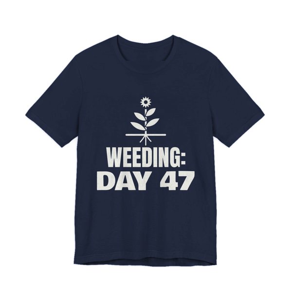 Navy t-shirt printed in off-white ink with a flowering weed with its roots and the words “Weeding: Day 47”
