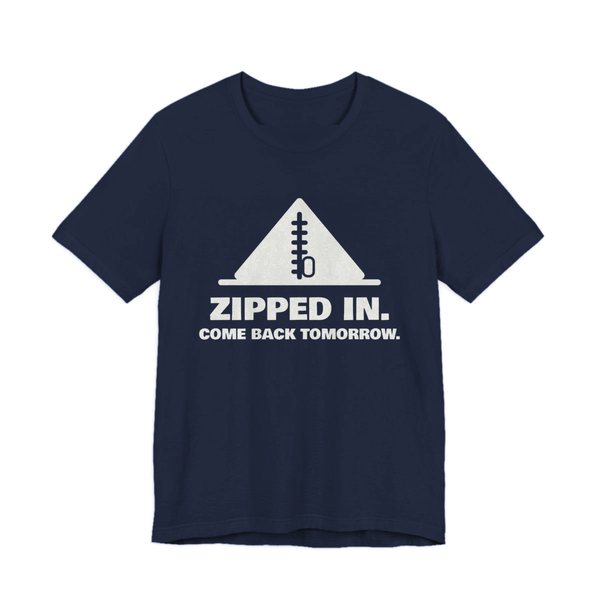Navy t-shirt printed in off-white ink with a zipped-up tent and the words “Zipped In. Come Back Tomorrow.”