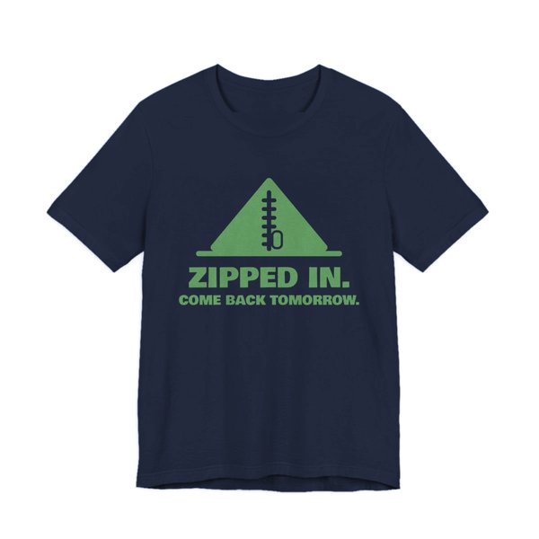 Navy t-shirt printed in pine green ink with a zipped-up tent and the words “Zipped In. Come Back Tomorrow.”
