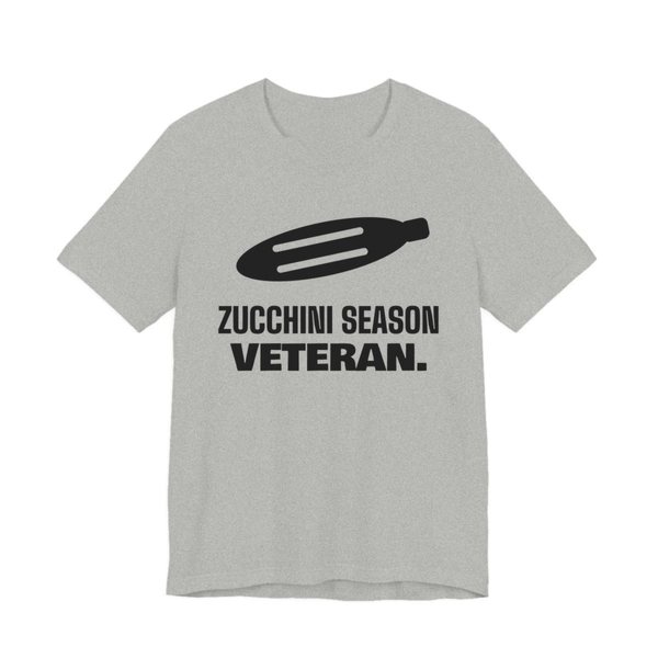 Athletic Heather t-shirt printed in dark ink with a big zucchini and the words “Zucchini Season Veteran.”