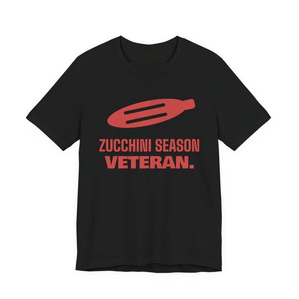 Black t-shirt printed in tomato red ink with a big zucchini and the words “Zucchini Season Veteran.”