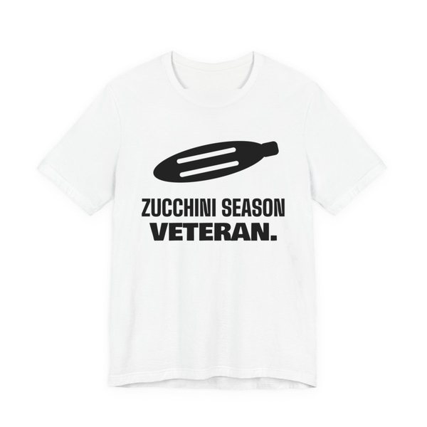 White t-shirt printed in dark ink with a big zucchini and the words “Zucchini Season Veteran.”